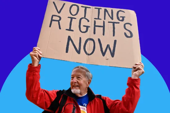 A man holds a sign that reads "voting rights now" against a blue background