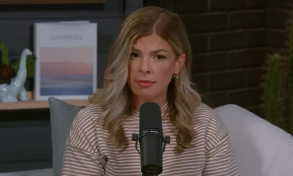 Allie Beth Stuckey, white woman with hair below her shoulders, speaks while seated behind a microphone in what appears to be a home office setting.