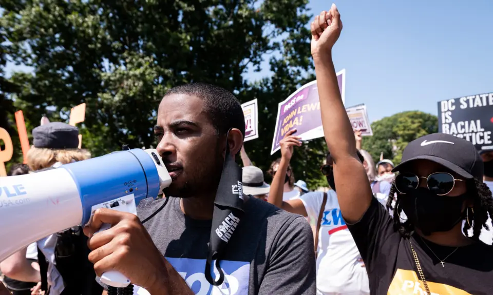 A black man holding a megaphone at a protest