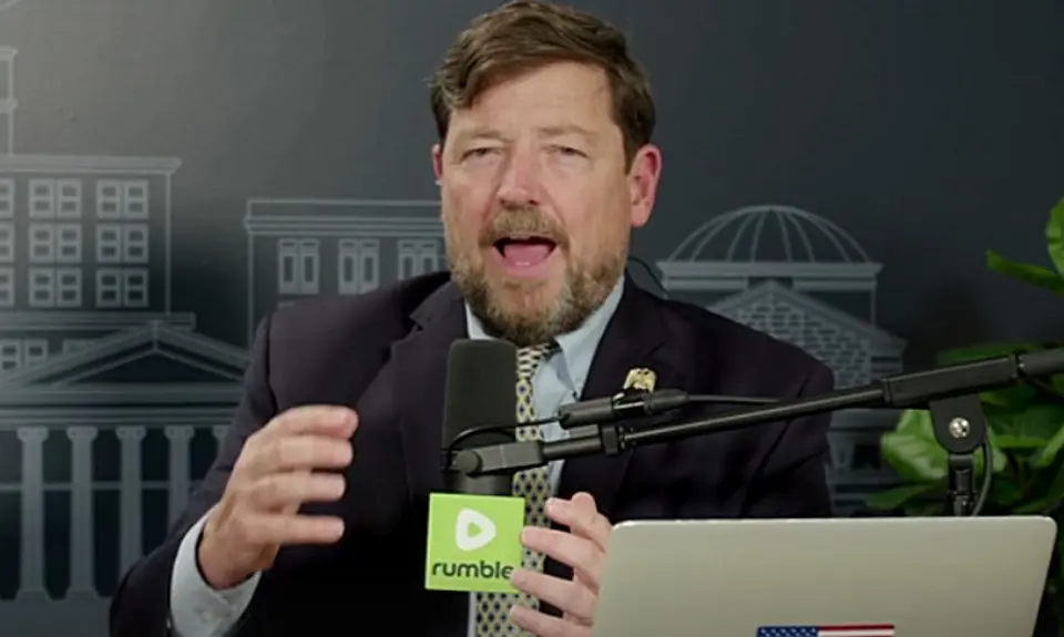 Ed Martin is on the set of his Pro America Report podcast, seated behind his laptop and a microphone bearing the logo of the Rumble video platform.