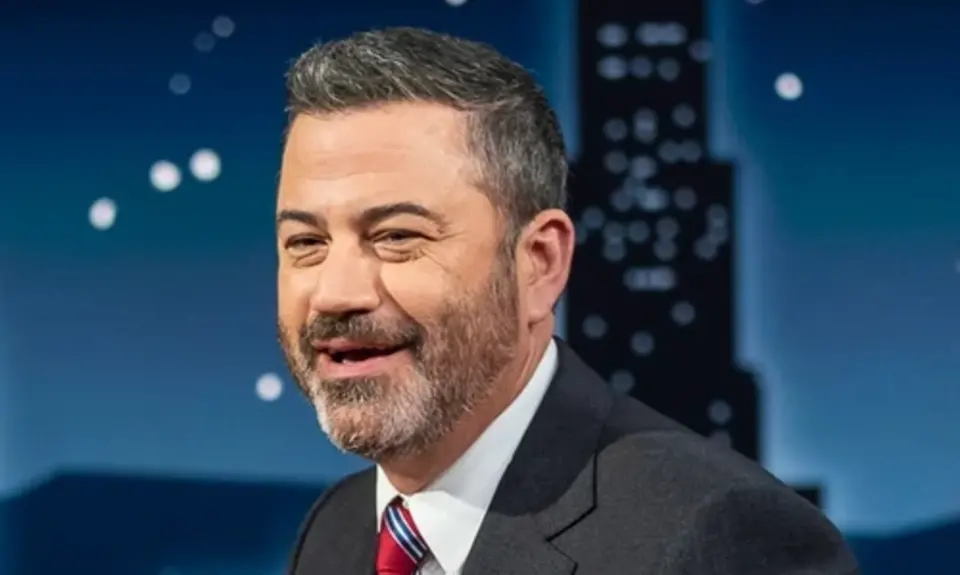 Jimmy Kimmel wearing a dark gray suit and red tie