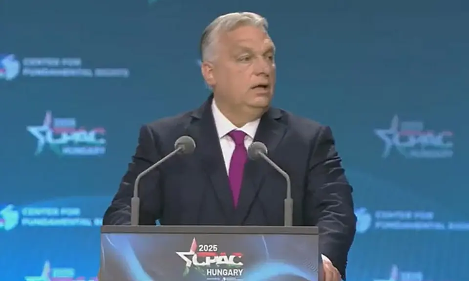 Viktor Orban stands at a lectern with logo for CPAC Hungary 2025, the logo is also visible on the backdrop behind him. 