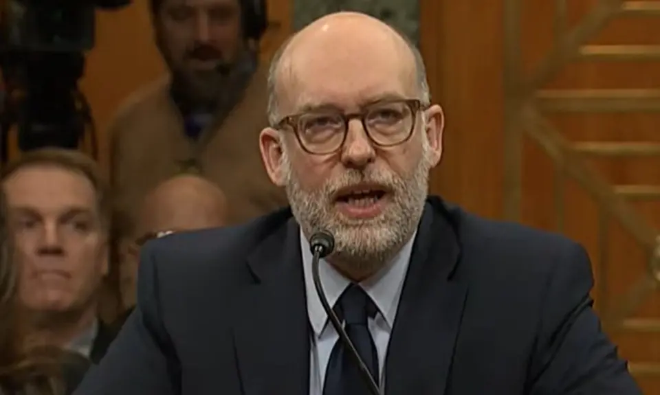 Russ Vought, in suit and tie, seated and speaking into a microphone.