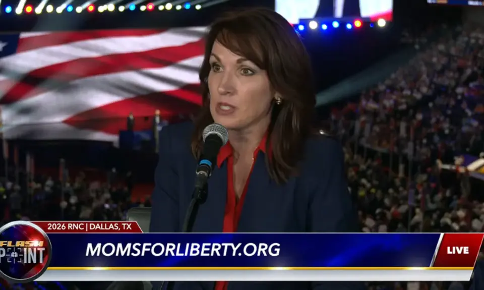 Tina Descovich is seated with a crowd shot of the RNC midterm convention behind her. Beneath her image is chyron with the logo for FlashPoint and text momsforliberty.org.