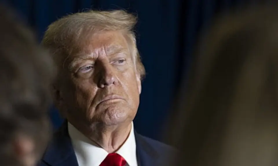 Photo of Trump gazing off camera, possibly listening to someone or assessing something he is looking at