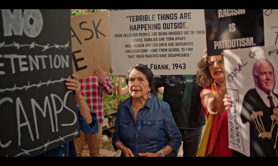 Activist Dolores Huerta surrounded by protestors rallying against ICE