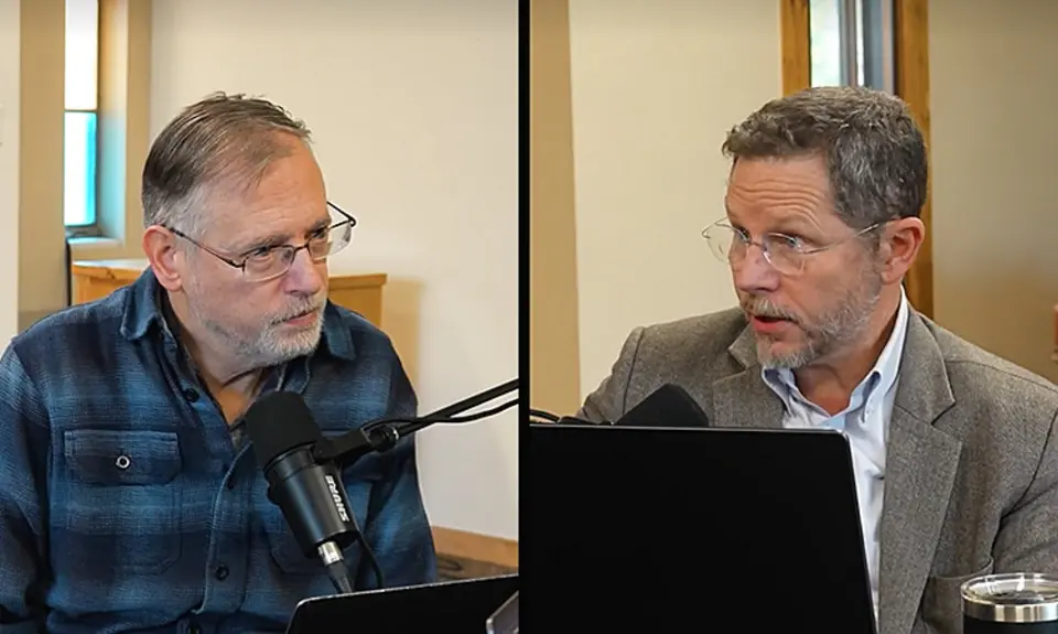 Split screen shows Kevin Swanson on the left, Raymond Simmons on the right, both seated in what appear to be modern church buildings. Swanson is speaking into a microphone and Simmonds has a laptop open in front of him. 