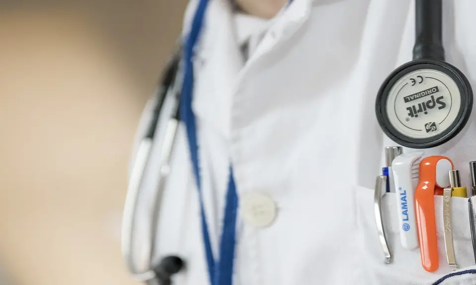 Close up of a doctor's stethoscope and pocket full of pens and pen lights