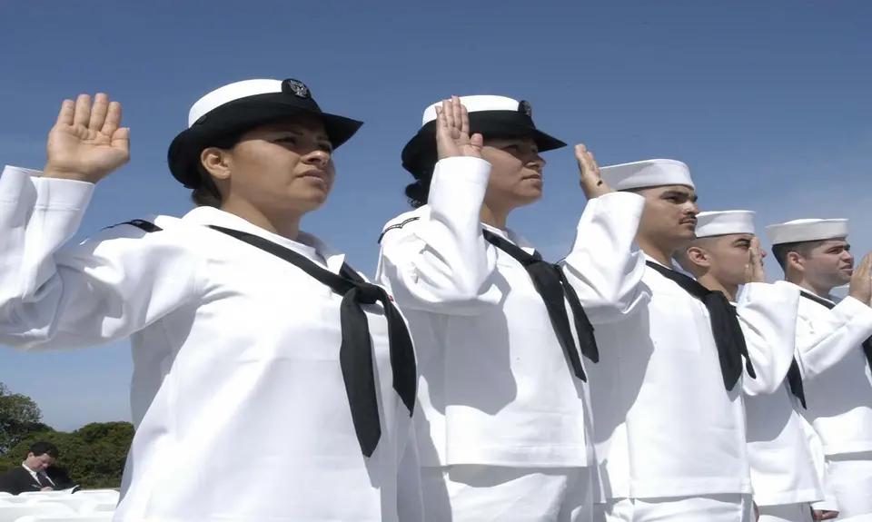 A line of Navy sailors take an oath.