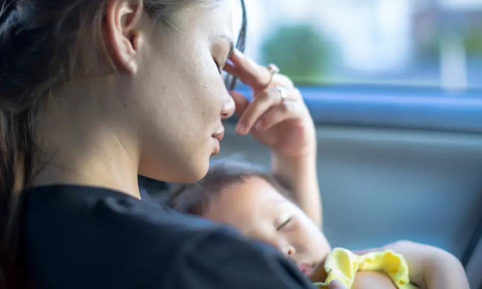 A young woman holds her baby.