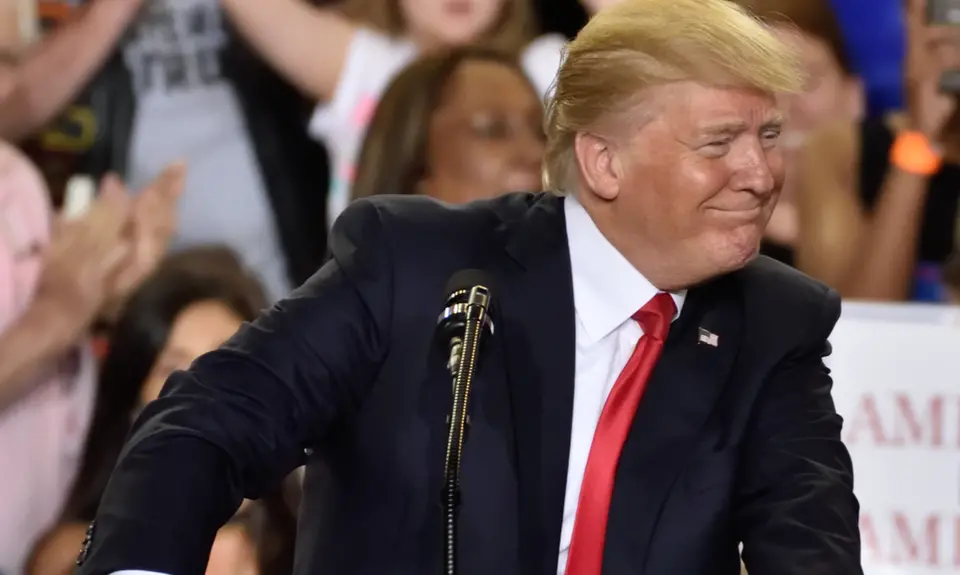 Donald Trump smiles in front of a podium