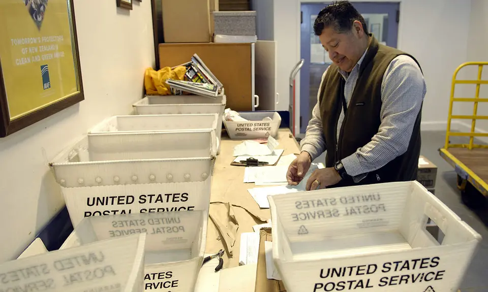 Postal worker sorts mail