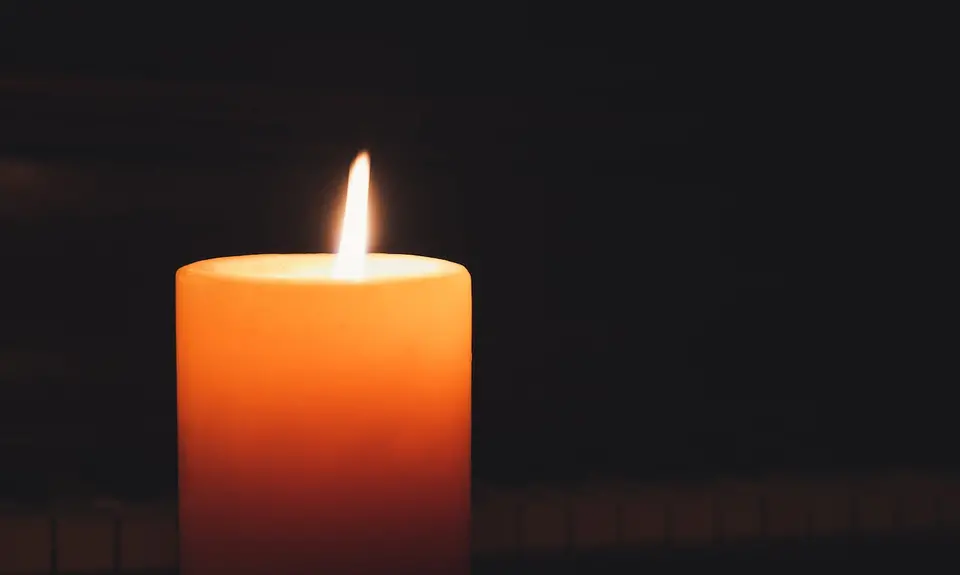 Lit candle in the dark