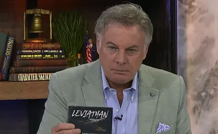 Lance Wallnau seated at a desk in front of a bookshelf, holding a CD he is promoting with LEVIATHAN visible on the label.