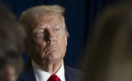 Photo of Trump gazing off camera, possibly listening to someone or assessing something he is looking at