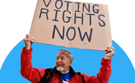 Man holding a sign that reads "voting rights now" 