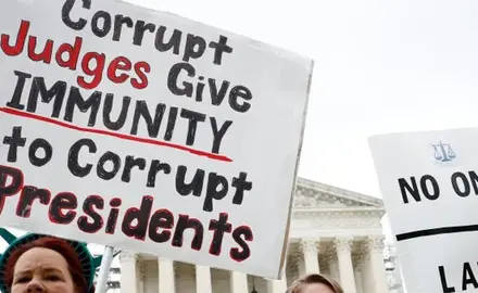 Protestors at the Supreme Court hold signs that read "No one is above the law."