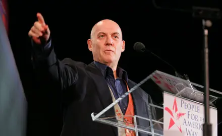 Howie Klein standing behind a podium 