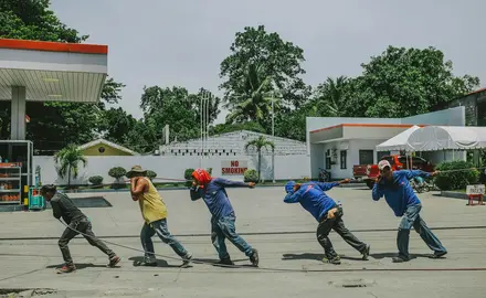 A group of five workers pull a rope