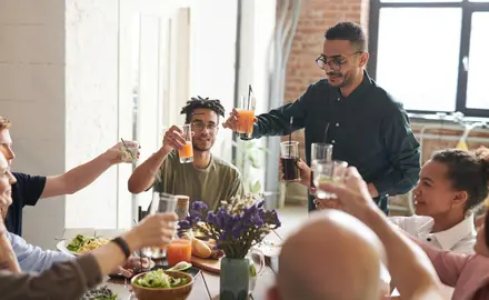 A group of people toast around a thanksgiving dinner
