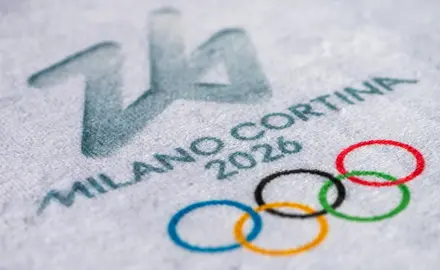 A close up of an ice rink that says "Milan Cortina 2026" and has the olympic logo