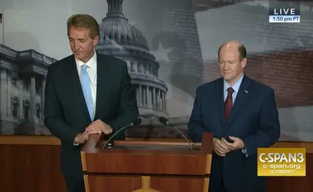 Jeff Flake and Chris Coons stand at a podium