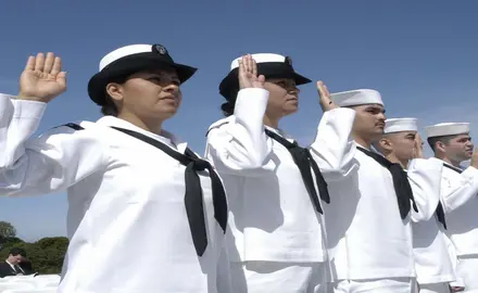 A line of Navy sailors take an oath.