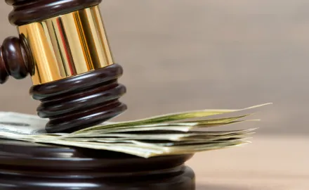 A gavel resting on a stack of money