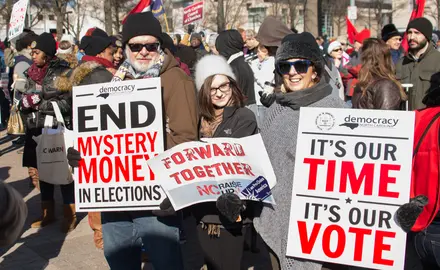 Protesters hold signs and participate in the 10th Annual Moral March