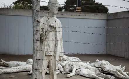 An art instillation depicting bodies laying on the ground and one man holding onto a barbed wire fence at the Holocaust Museum