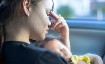 A young woman holds her baby.