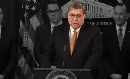 William Barr speaking at a podium