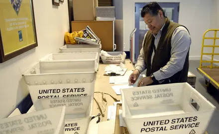 Postal worker sorts mail