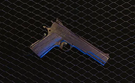 A black gun sitting on a black grate