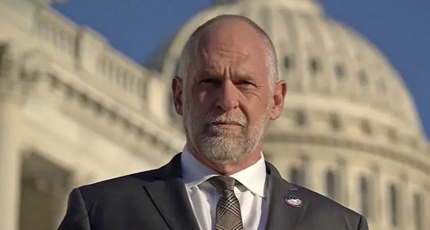 IFA President David Kubal, a balding white man in suit and tie, looks sternly into the camera with the US Capitol dome visible behind him. 
