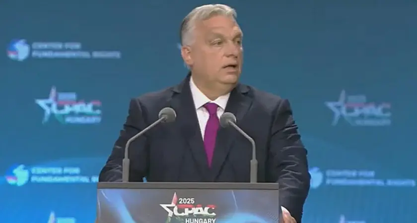 Viktor Orban stands at a lectern with logo for CPAC Hungary 2025, the logo is also visible on the backdrop behind him. 
