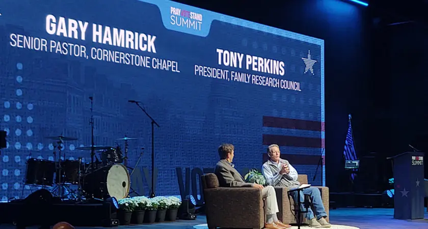 Cornerstone Chapel pastor Gary Hamrick and FRC President Tony Perkins sit on stage at the 2026 Pray Vote Stand summit with their names and IDs projected on the backdrop behind them.
