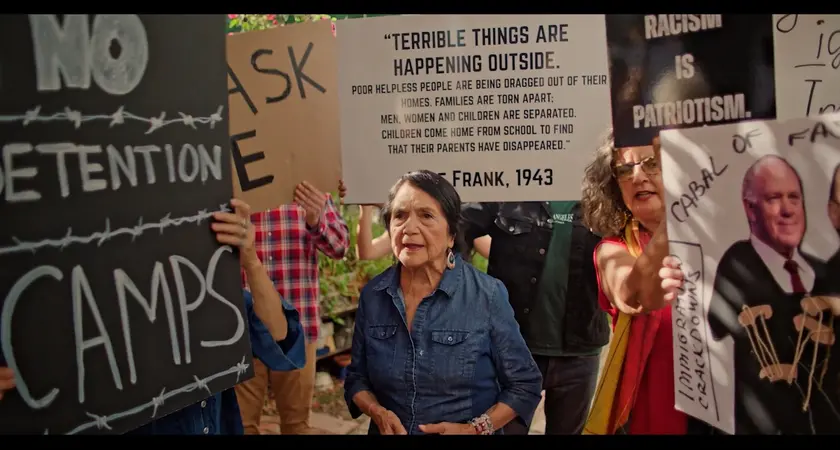 Activist Dolores Huerta surrounded by protestors rallying against ICE