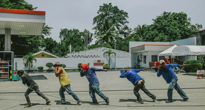A group of five workers pull a rope