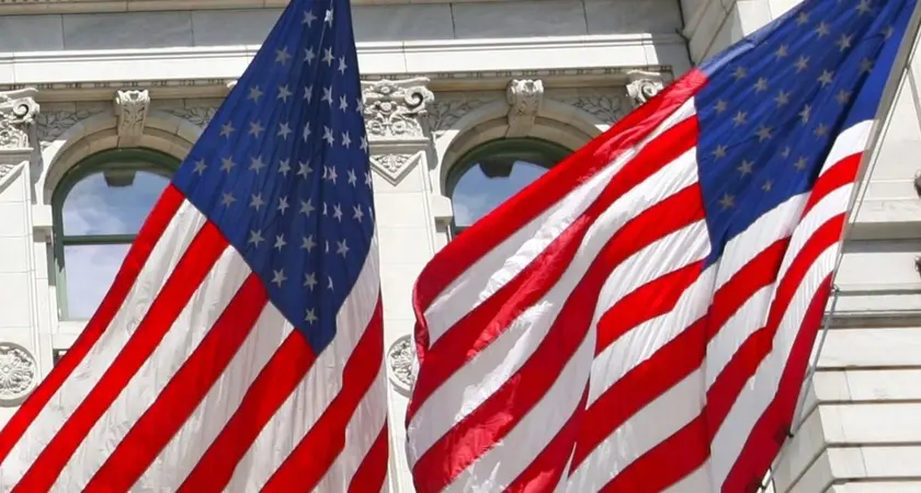 picture of two American flags against a white building