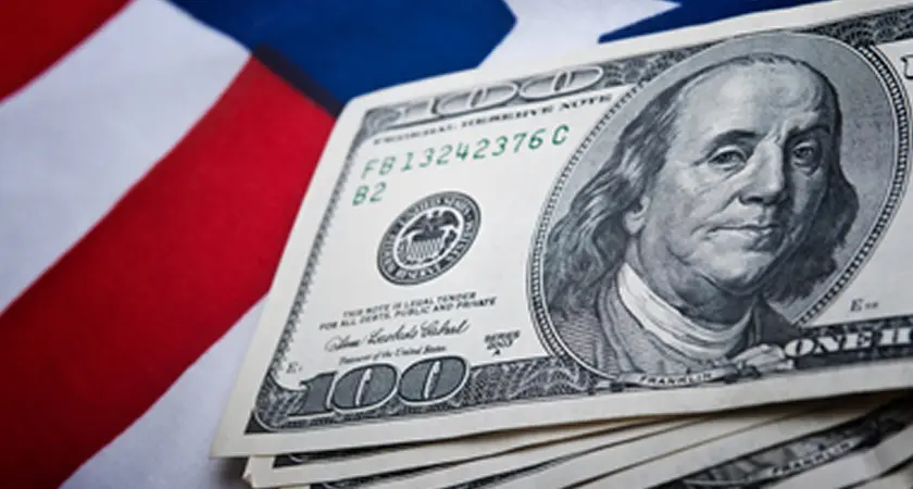 Hundred dollar bills over the American flag.