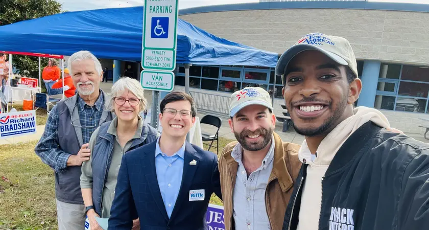 Markus Batchelor and Josh San Miguel posing outdoors with Randy Riffle and two others.