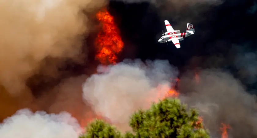 And airplane flying over a forest fire