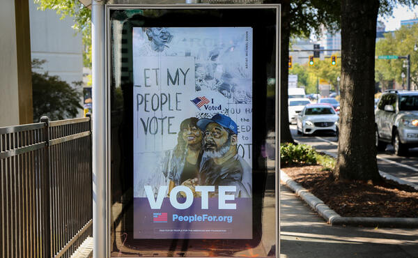 A photo of artwork at a bus stop in Atlanta featuring the work "let my people vote" by Michael Dixon.