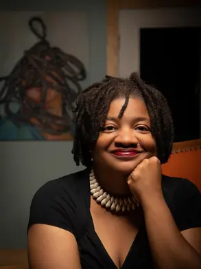 A photo of Beverly McIver, a Black woman wearing a black top and a necklace