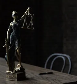A statue of lady justice sitting on a table.