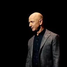 Jeff Bezos wearing a gray suit in front of a black background