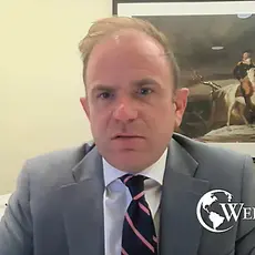 Matthew Henderson, a balding white man in suit and tie, speaks into the camera. The logo of Jim Garlow's Well Versed ministry is shown in the lower right corner. 