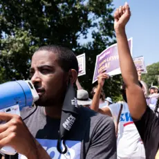 A black man holding a megaphone at a protest