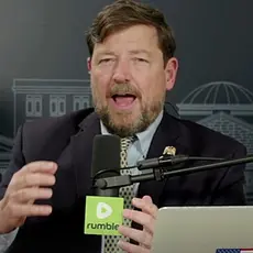 Ed Martin is on the set of his Pro America Report podcast, seated behind his laptop and a microphone bearing the logo of the Rumble video platform.